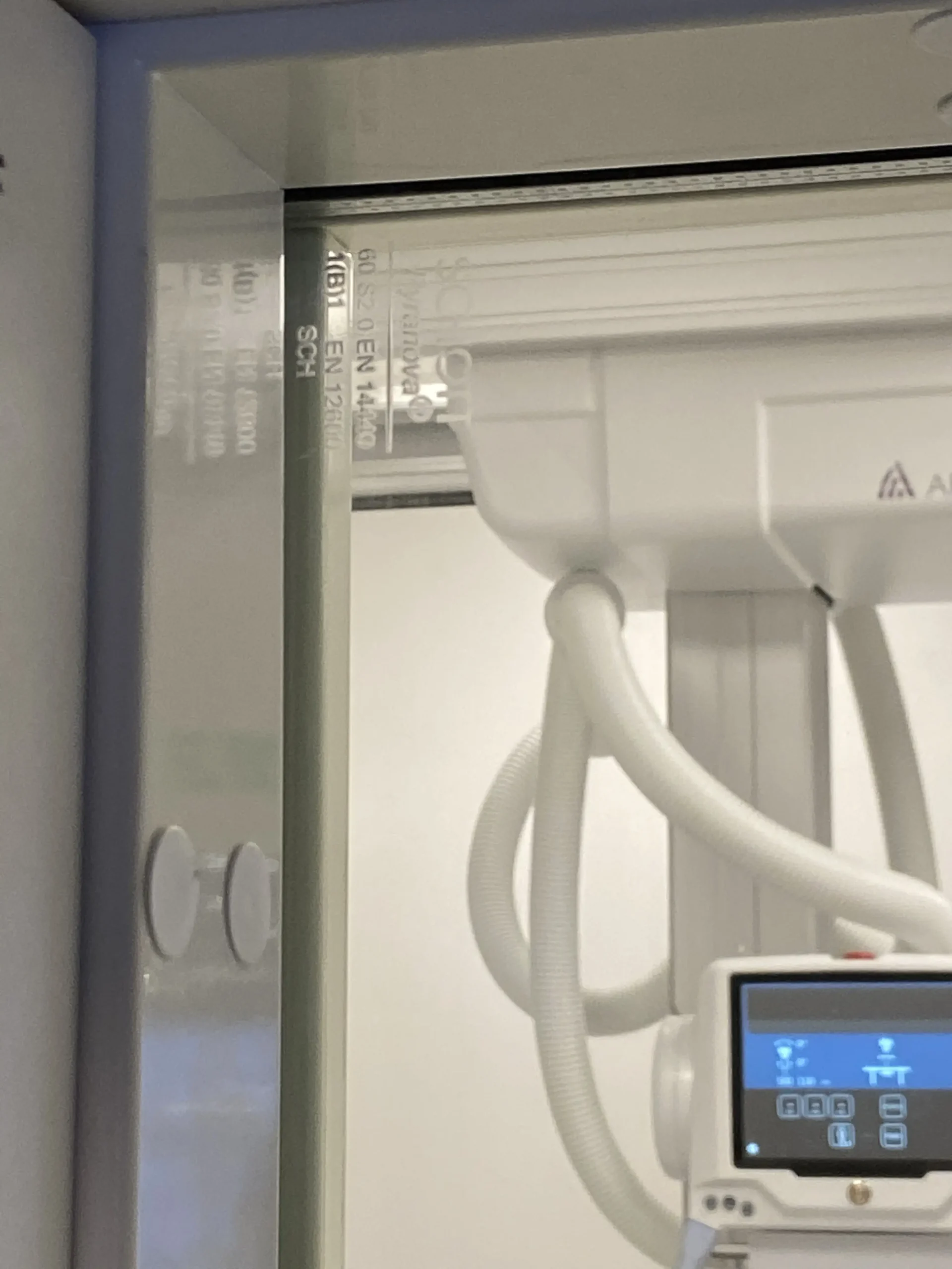 röntgenutrustning Röntgenutrustning skymtas på andra sidan om ett strålskyddsglas.